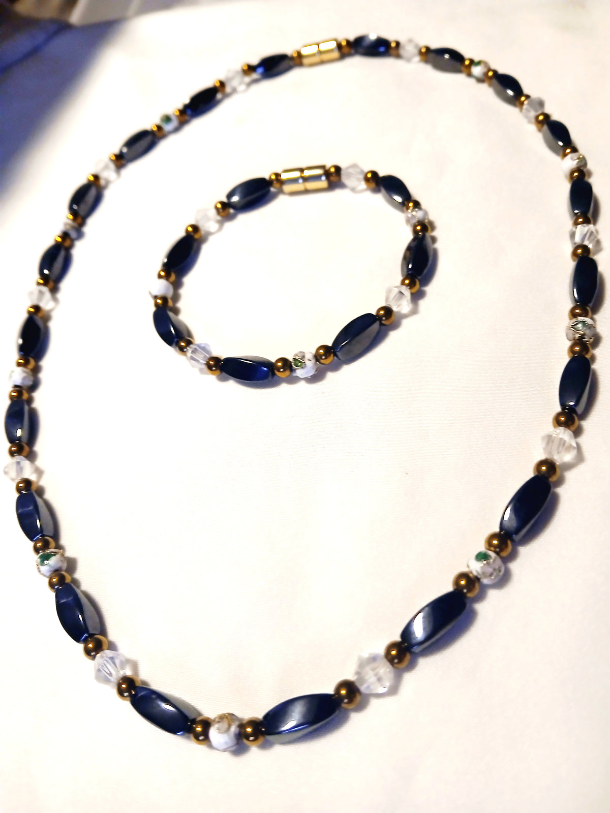 Navy blue and gold magnetic jewelry set with clear crystal accents, featuring a timeless elegant necklace and matching bracelet.